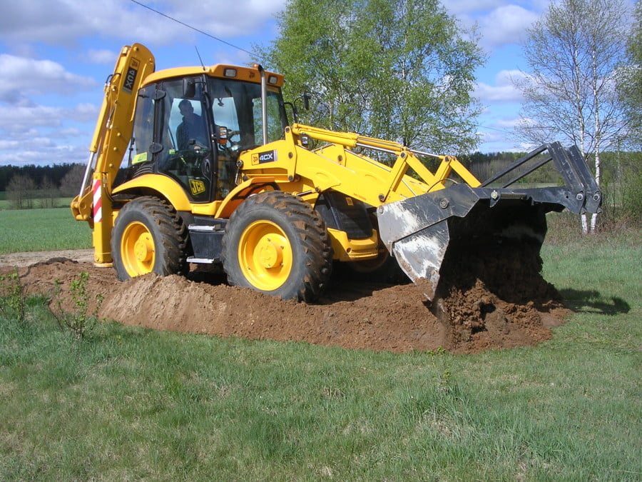 Koparko-ładowarka JCB 4CX podczas pracy w terenie